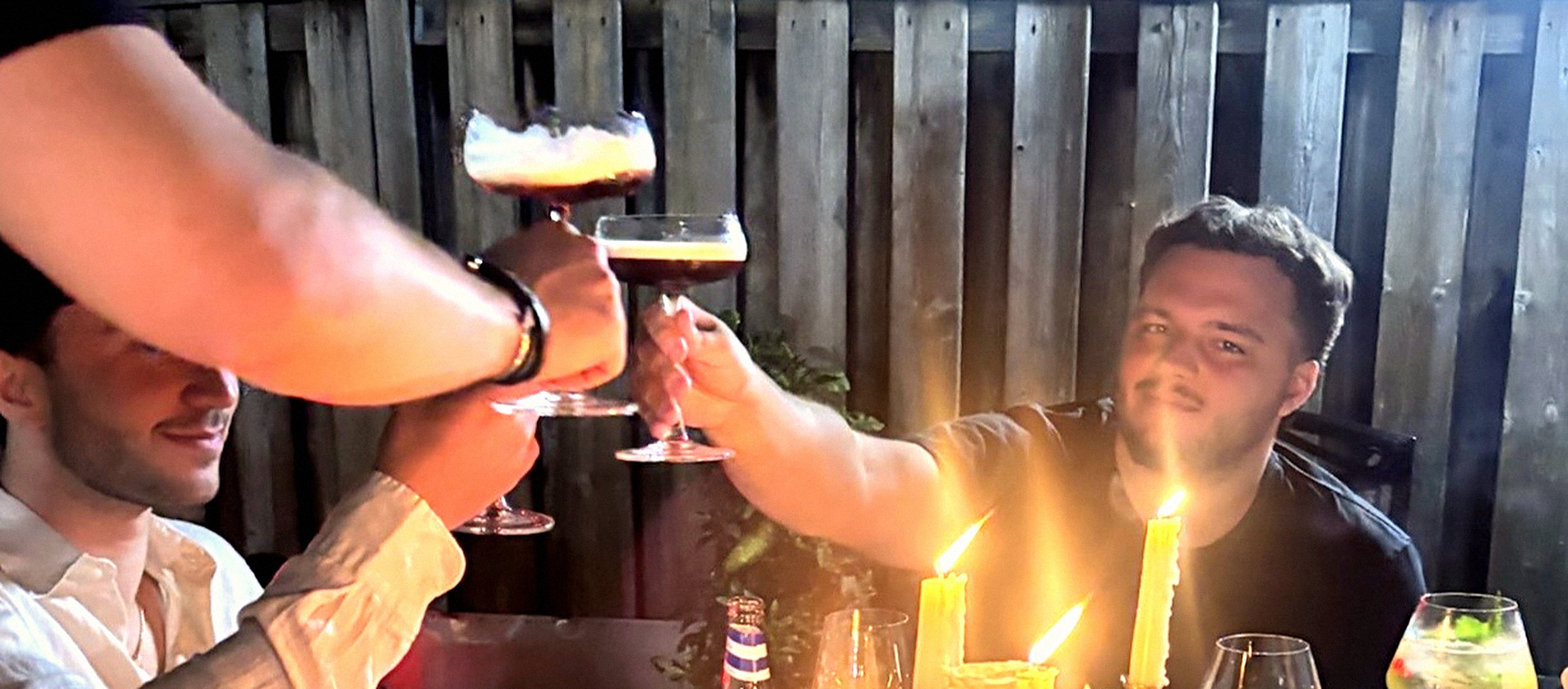 Guests raising espresso martinis at a candlelit table